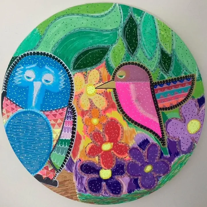 Round hand-painted artwork of two colourful birds among flowers