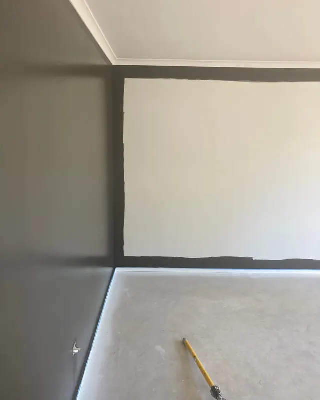 Dark paint cut in neatly around the edges of a wall beside a finished dark wall
